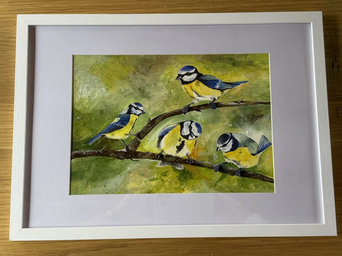 Flock: acrylic painting of four blue tits on a branch against a green background, mounted in a white frame.